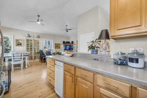 Kitchen with ceiling fan, vaulted ceiling, light brown cabinetry, and light hardwood / wood-style flooring