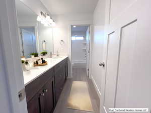 Full bathroom with vanity, toilet, shower / tub combination, and hardwood / wood-style flooring