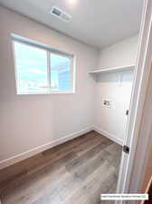 Clothes washing area featuring hookup for a washing machine and hardwood / wood-style floors