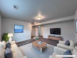 Carpeted living room with a textured ceiling