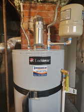 Utility room featuring water heater that was recently replaced.