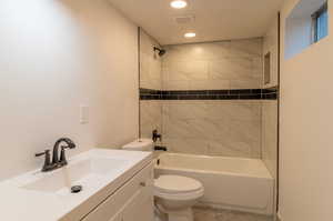 Newly tiled shower, vanity, and toilet with tiled floors