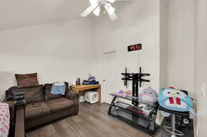 Interior space with a towering ceiling, wood-type flooring, and ceiling fan