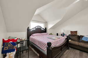 Bedroom featuring vaulted ceiling and hardwood / wood-style flooring