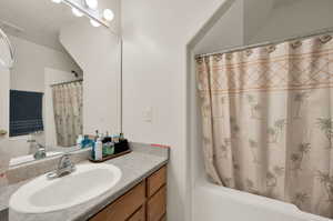 Bathroom featuring vanity and shower / tub combo with curtain