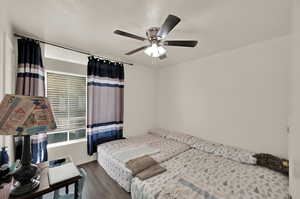 Bedroom with ceiling fan and dark hardwood / wood-style floors