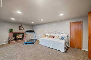 Carpeted bedroom with a fireplace and a textured ceiling