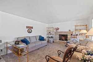 Carpeted living room featuring a textured ceiling and a fireplace