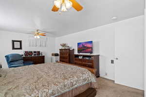 Carpeted bedroom with a textured ceiling and ceiling fan