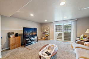 Living room with a textured ceiling and carpet floors