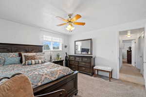 Bedroom with a textured ceiling, light colored carpet, and ceiling fan