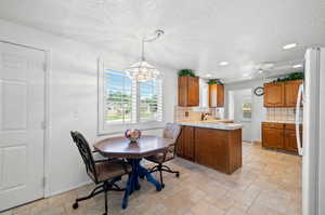 Interior space featuring ceiling fan with notable chandelier, a textured ceiling, and sink