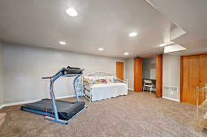 Bedroom featuring carpet and a textured ceiling