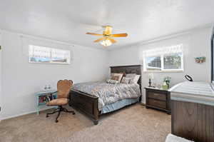 Bedroom featuring light carpet, a textured ceiling, and ceiling fan