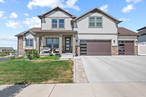 Craftsman inspired home with a garage and a front yard