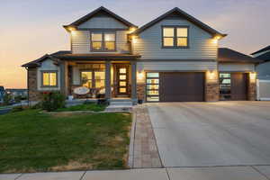 View of front facade with a lawn, a garage, and a porch