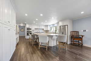 Kitchen featuring white cabinets, appliances with stainless steel finishes, and dark hardwood / wood-style floors