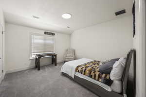 Bedroom with lofted ceiling, carpet, and a textured ceiling