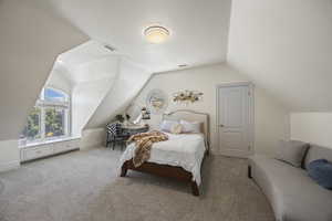 Carpeted bedroom with a textured ceiling and vaulted ceiling