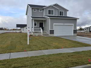 View of front of house featuring a garage and a front lawn