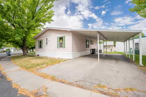 View of front facade with a front yard and a carport