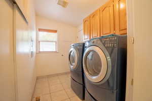 Laundry room featuring cabinets, separate washer and dryer, and light tile patterned flooring