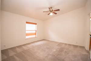 Spare room with ceiling fan and carpet flooring