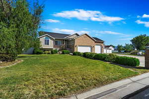 View of front of house featuring a garage and a front lawn