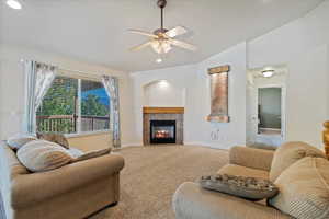 Living room with carpet, ceiling fan, and a fireplace