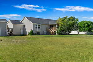 Rear view of property with a yard and a deck