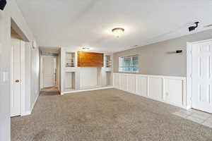 Unfurnished living room with a textured ceiling and light colored carpet