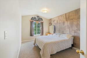 Bedroom with carpet and vaulted ceiling