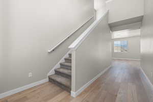 Stairs featuring hardwood / wood-style flooring