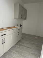 Washroom with electric dryer hookup, cabinets, and washer hookup