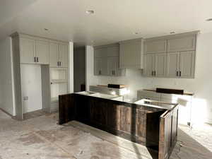 Kitchen featuring gray cabinets, light wood-type flooring, and a textured ceiling