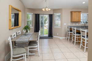 Dining area with light tile patterned floors and a chandelier