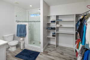 Bathroom with toilet, wood-type flooring, an enclosed shower, and vanity