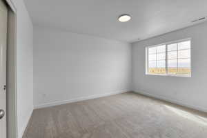 Carpeted spare room with a textured ceiling