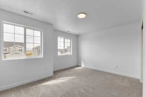 Carpeted empty room featuring a textured ceiling