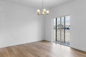 Empty room featuring light hardwood / wood-style flooring and a chandelier