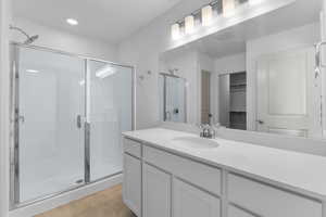 Bathroom featuring tile patterned flooring, walk in shower, and vanity