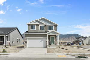 Craftsman inspired home featuring a mountain view, a garage, and a porch