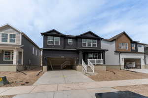 Craftsman house with driveway, covered porch, board and batten siding, and an attached garage