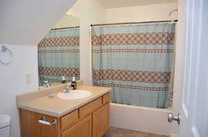 Full bathroom featuring vanity, toilet, tile patterned floors, and shower / bath combination with curtain