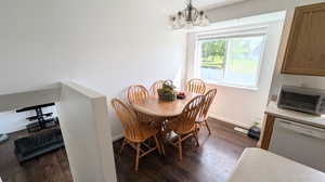 Dining room featuring an inviting chandelier and dark hardwood / wood-style floors