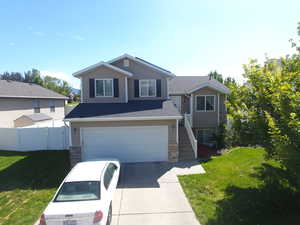 View of front facade featuring a garage and a front yard