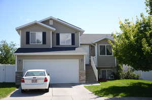 Split level home with a garage and a front yard