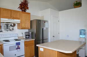 Kitchen with lofted ceiling, stainless steel fridge, and white electric range oven