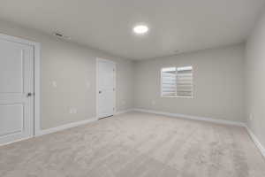 Unfurnished room featuring light carpet