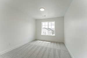 Carpeted empty room featuring baseboards and a textured ceiling